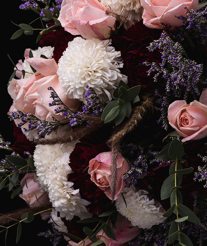 Composizione di fiori per funerale con rose rosa, crisantemi bianchi e lavanda